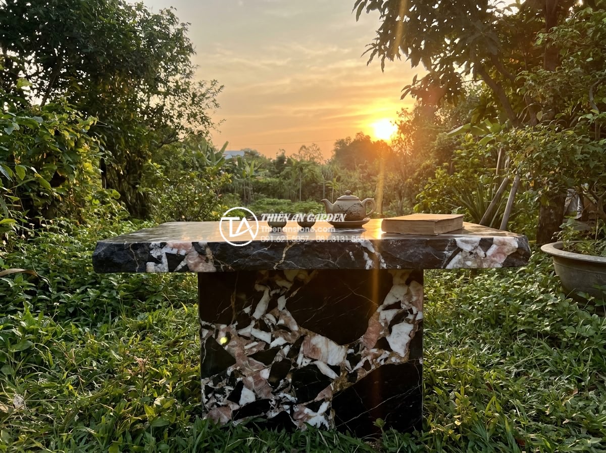 Bàn Trà Đá Nguyên Khối - Contemplative scene of a person sitting alone at a natural stone tea table in a 