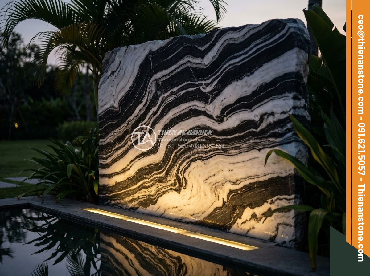 Bảng Hiệu Đá Tự Nhiên - Detail of resort stone sign at dusk, warm accent lighting from below, water refl