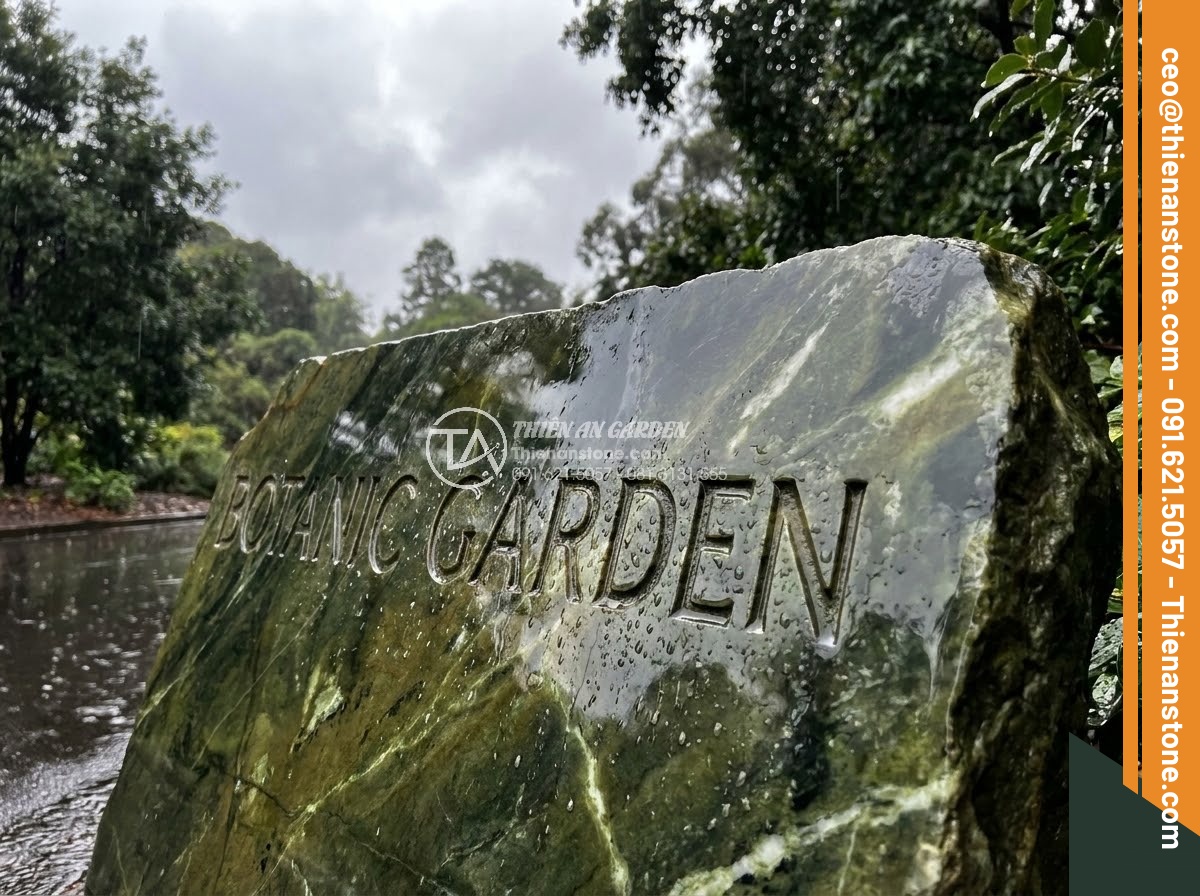 Bảng Hiệu Đá Tự Nhiên - Natural stone sign after rain with wet surface reflecting sky and surrounding tr