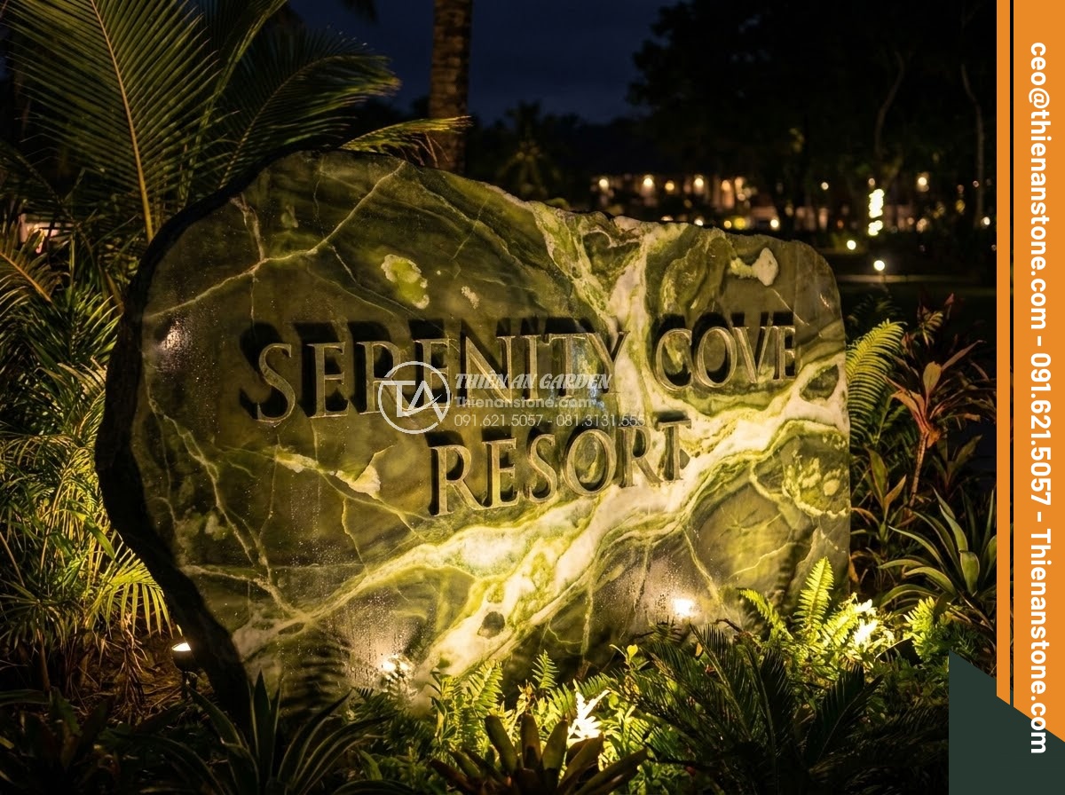 Bảng Hiệu Đá Tự Nhiên - Natural stone sign illuminated by warm up-lighting at night, dramatic shadows on