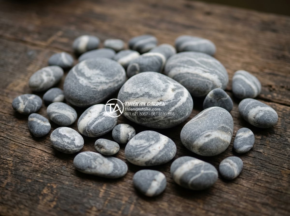 Đá Cuội Vân Mây - Collection of various sized cloud vein pebble stones displayed on wooden surface