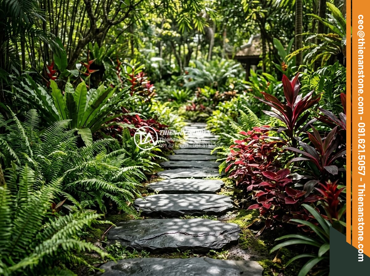 Đá Dặm Bước - Stepping stones pathway lined with ornamental ferns and red-leaf plants, dappled