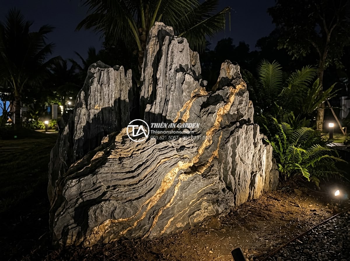 Đá Trầm Tích - Sedimentary rock illuminated by warm LED garden spotlights at night, dramatic sh