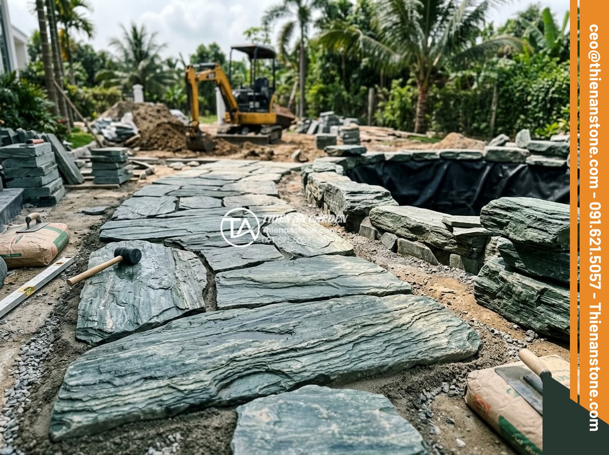 Thiết Kế Sân Vườn - Construction phase of a luxury garden project showing workers laying natural sto