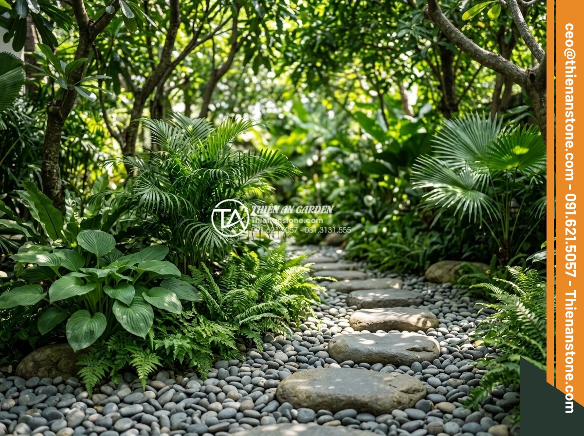 Tiểu Cảnh Đá Cuội - Tropical garden corner with smooth grey pebbles covering the ground around lush 