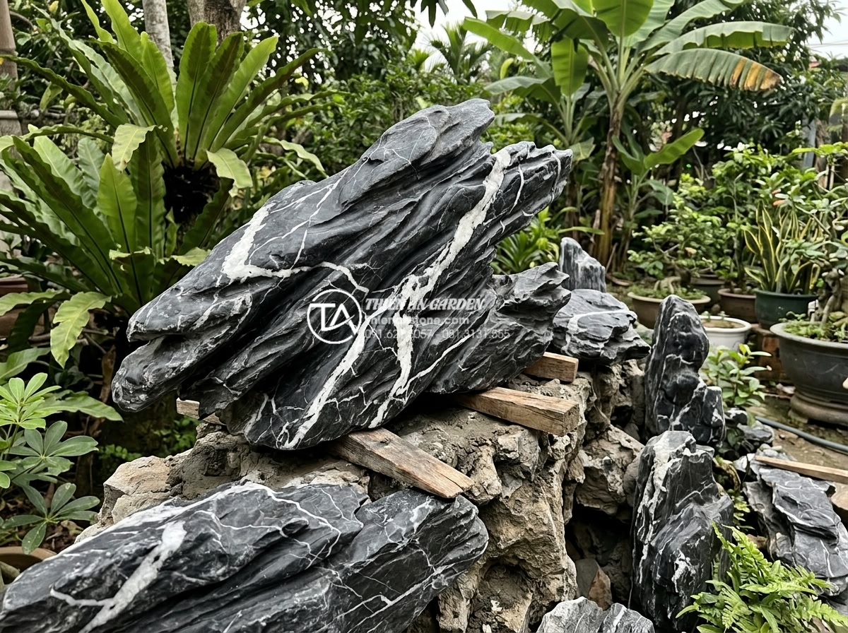Tiểu Cảnh Non Bộ Sân Vườn - Artisan carefully positioning large natural stone piece on rockery structure, us