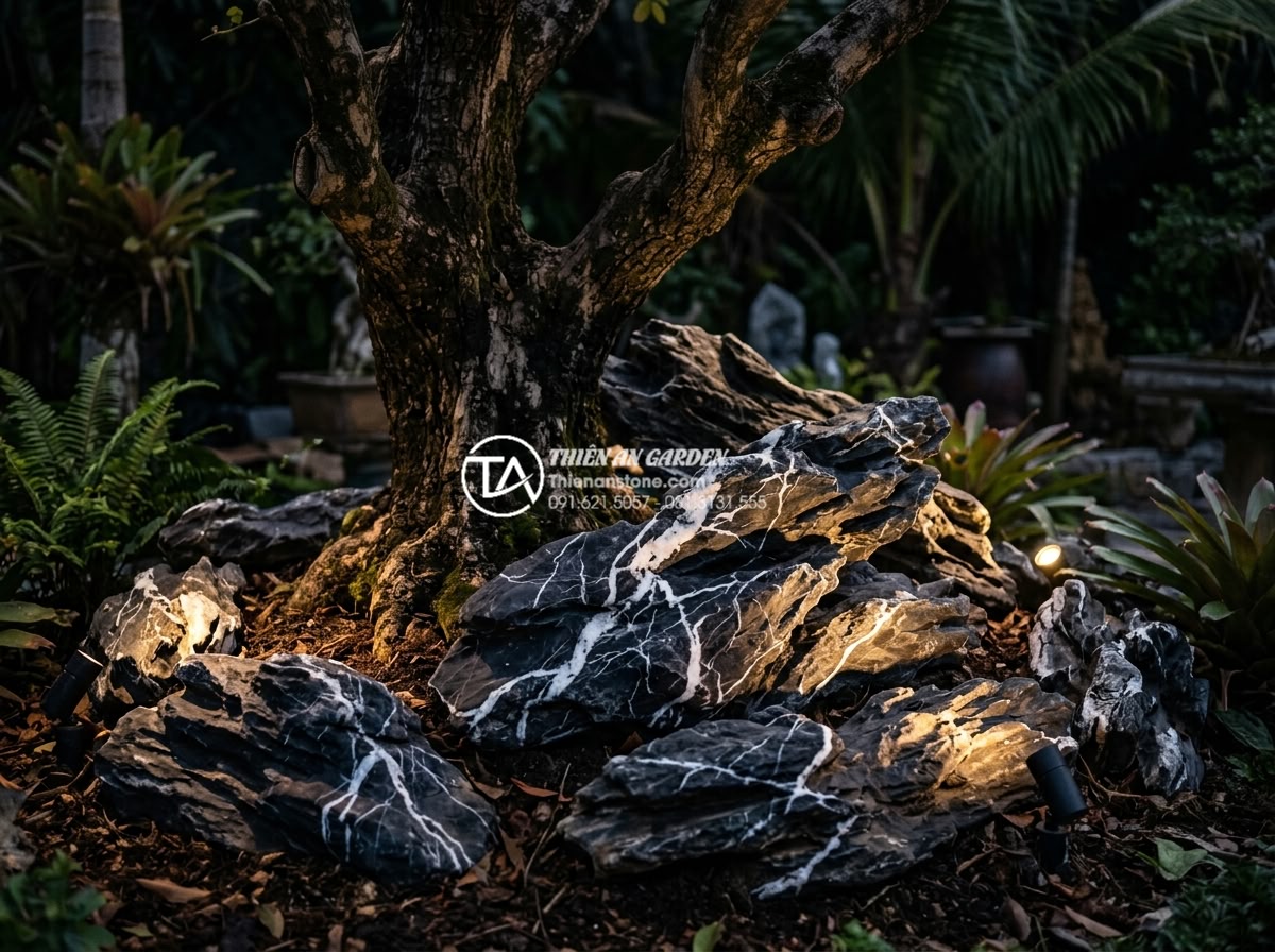 Kết hợp đèn sân vườn cho tiểu cảnh gốc cây: Bí quyết lung linh về đêm - Close-up night view of natural stone arrangement around tree base illuminated by