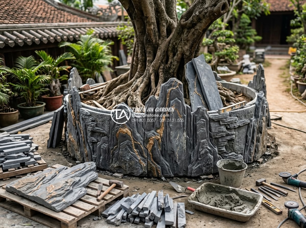 Mẫu tiểu cảnh gốc cây kết hợp tranh đá ốp tường độc đáo - On-site construction photograph showing skilled craftsmen installing hand-carved