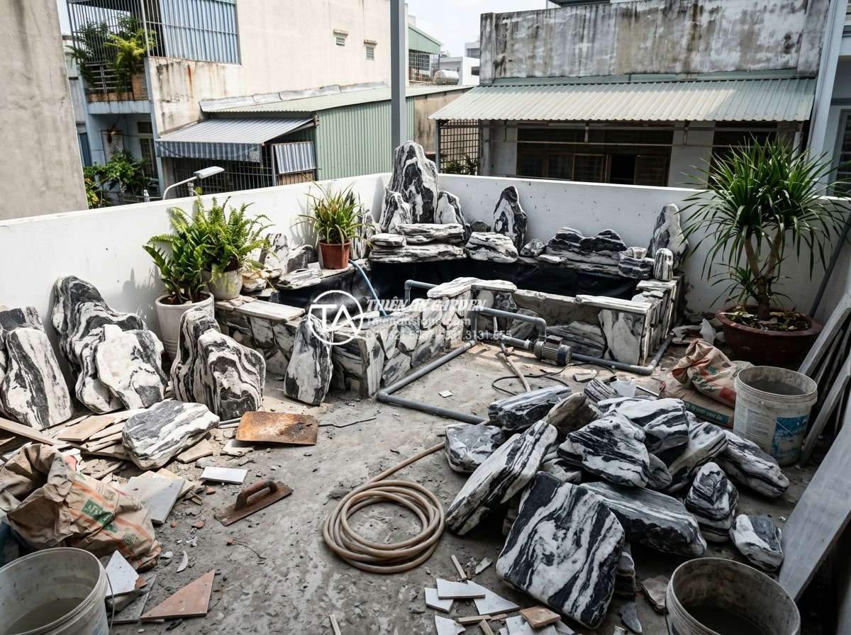 7 Sai lầm phổ biến khiến tiểu cảnh ban công nhanh hỏng và cách khắc phục - Chaotic unfinished balcony project with scattered stones, incomplete water featu