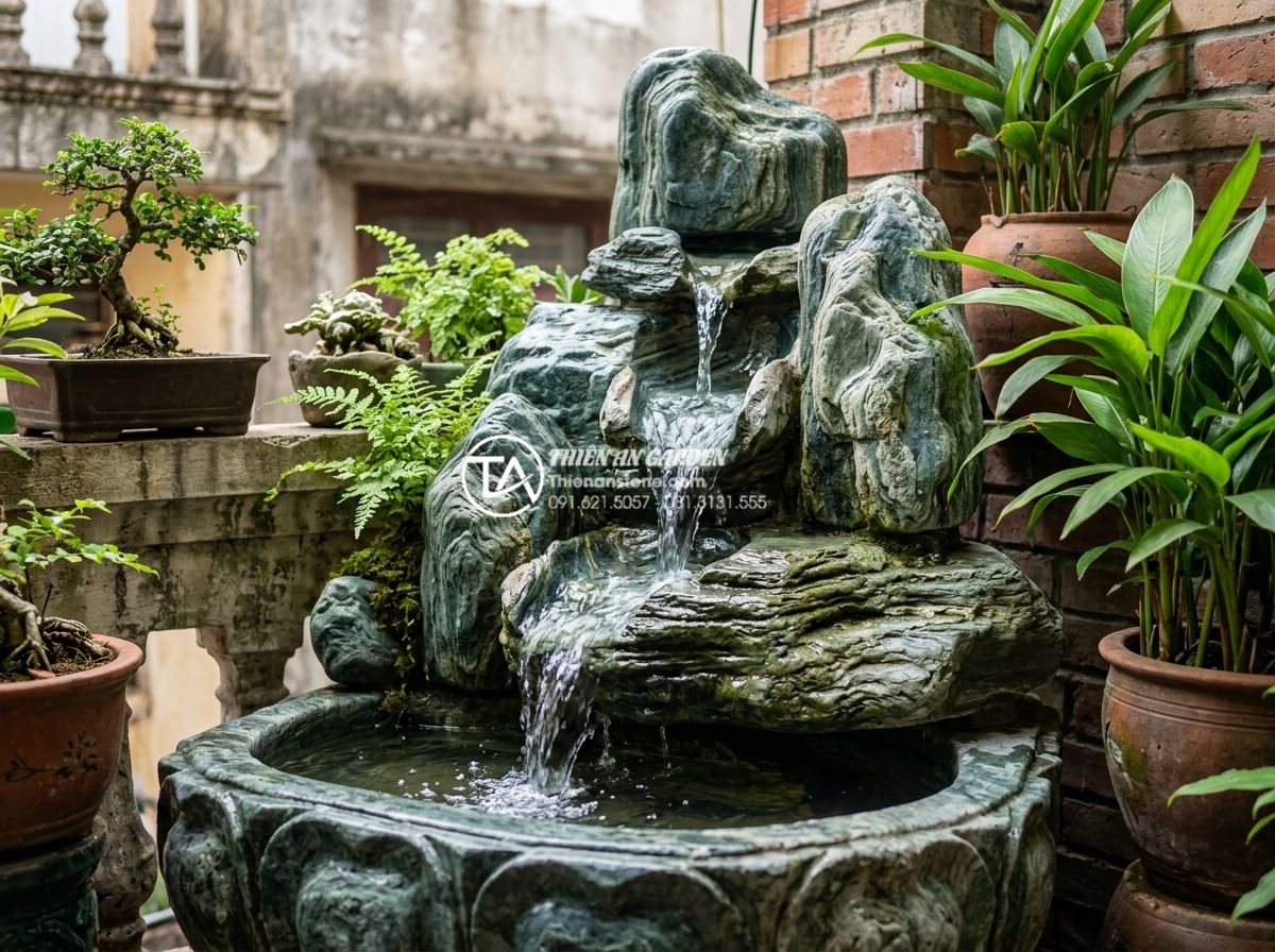 Mẫu tiểu cảnh ban công kết hợp thác nước bằng đá tự nhiên cực sang trọng - Elegant close-up of natural stone carved waterfall feature on a compact urban ba