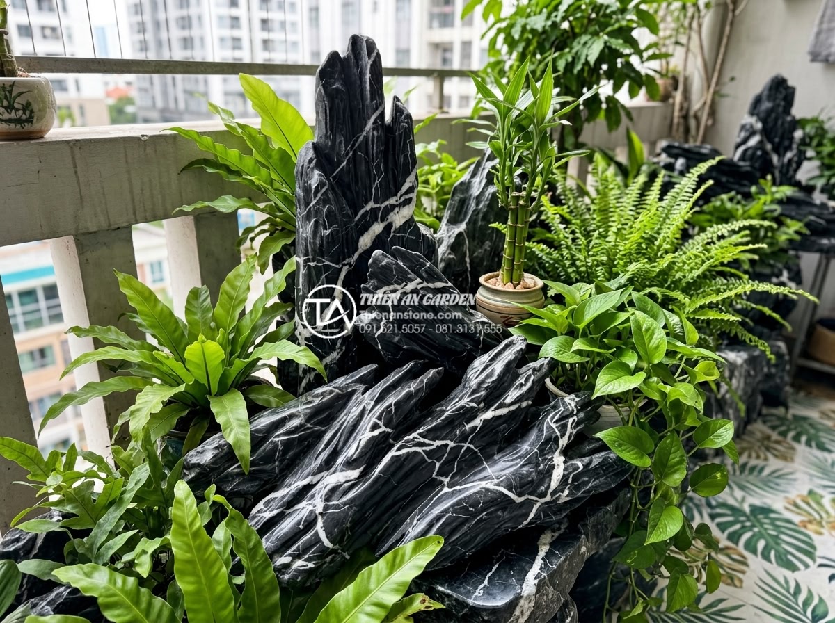 Phong thủy tiểu cảnh ban công: Cách bố trí đá và cây xanh hút tài lộc - Hình 2 Phong thủy tiểu cảnh ban công: Cách bố trí đá và cây xanh hút tài lộc - Close-up of carved natural stone elements combined with vibrant green foliage on
