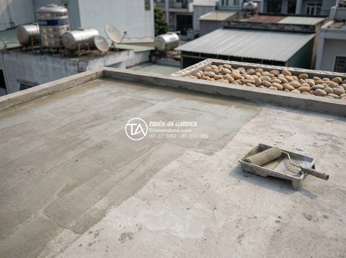 Quy trình chống thấm sân thượng triệt để trước khi làm tiểu cảnh nước - Hình 9 Quy trình chống thấm sân thượng triệt để trước khi làm tiểu cảnh nước - Step-by-step waterproofing application process showing primer layer on concrete