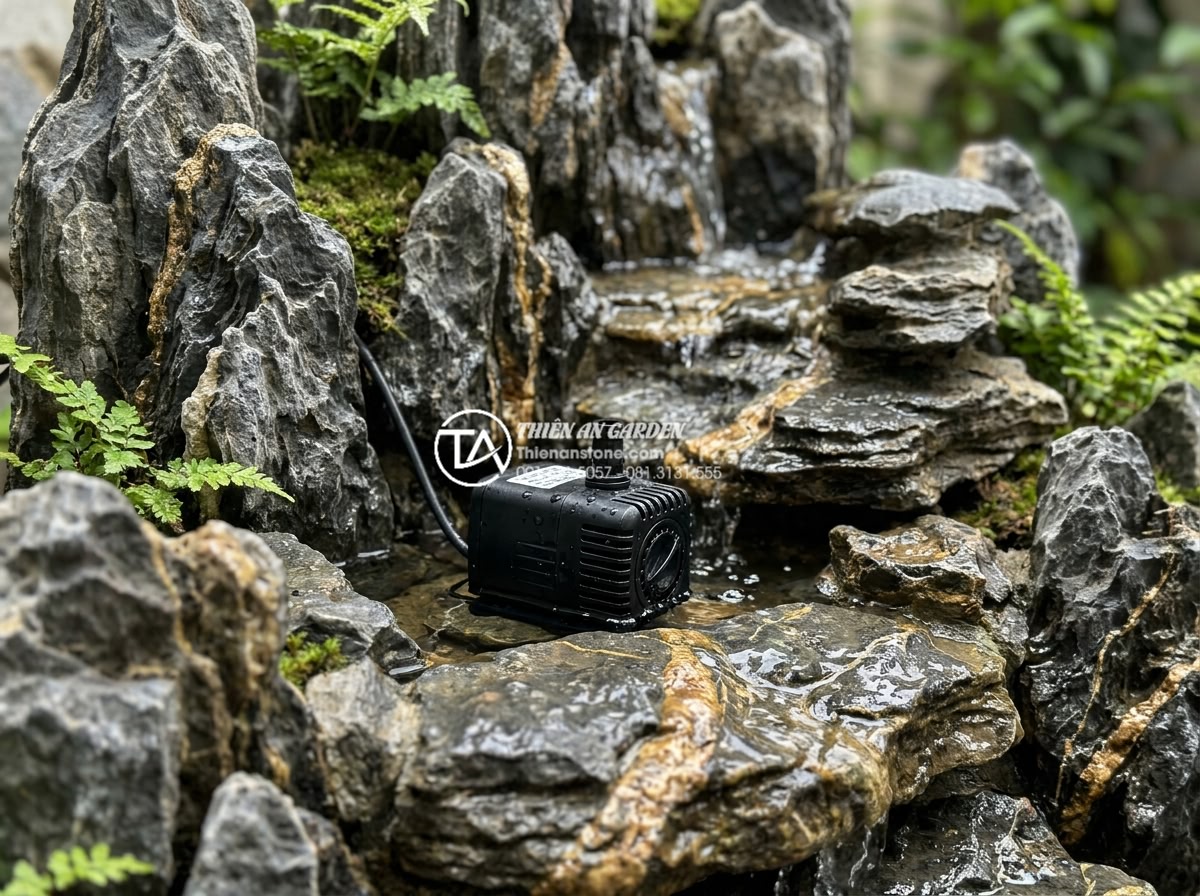 Review các loại máy bơm mini chuyên dụng cho tiểu cảnh nước góc sân - Close-up view of a compact mini submersible water pump placed inside a small cor