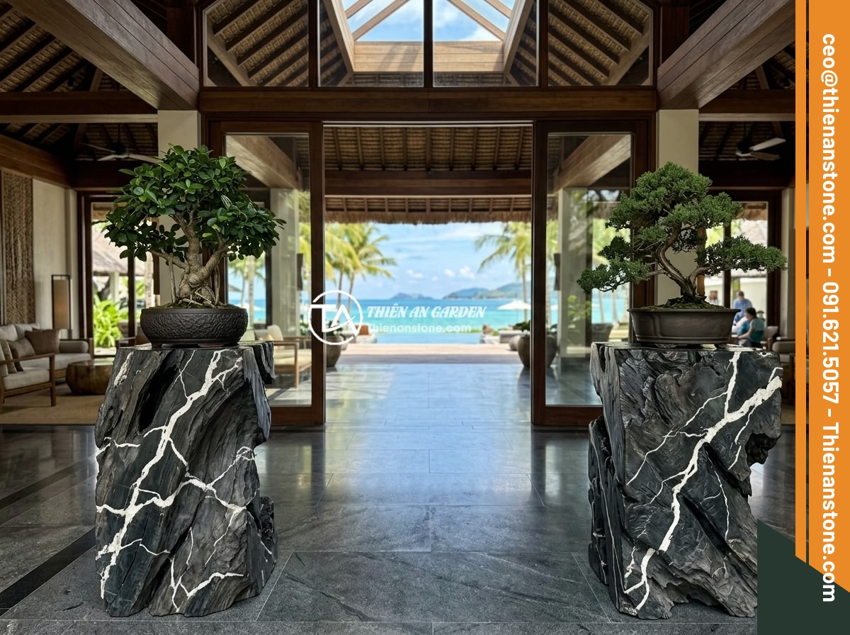 Đôn kê cây đá lũa đen - Hình 11 Đôn kê cây đá lũa đen - Luxury tropical resort lobby featuring two large black driftwood stone pedestals