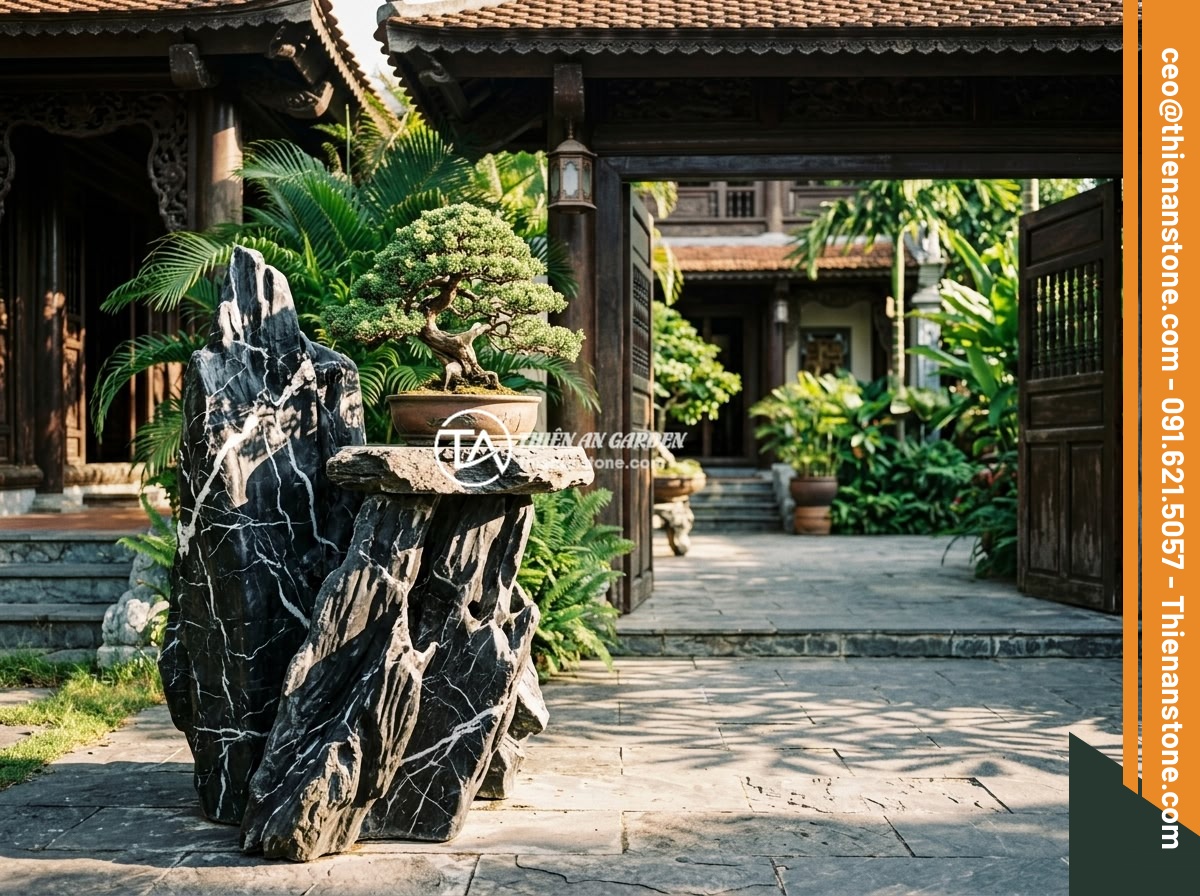 Đôn kê cây đá lũa đen - Hình 2 Đôn kê cây đá lũa đen - Wide angle view of a black driftwood stone plant stand placed at the entrance of