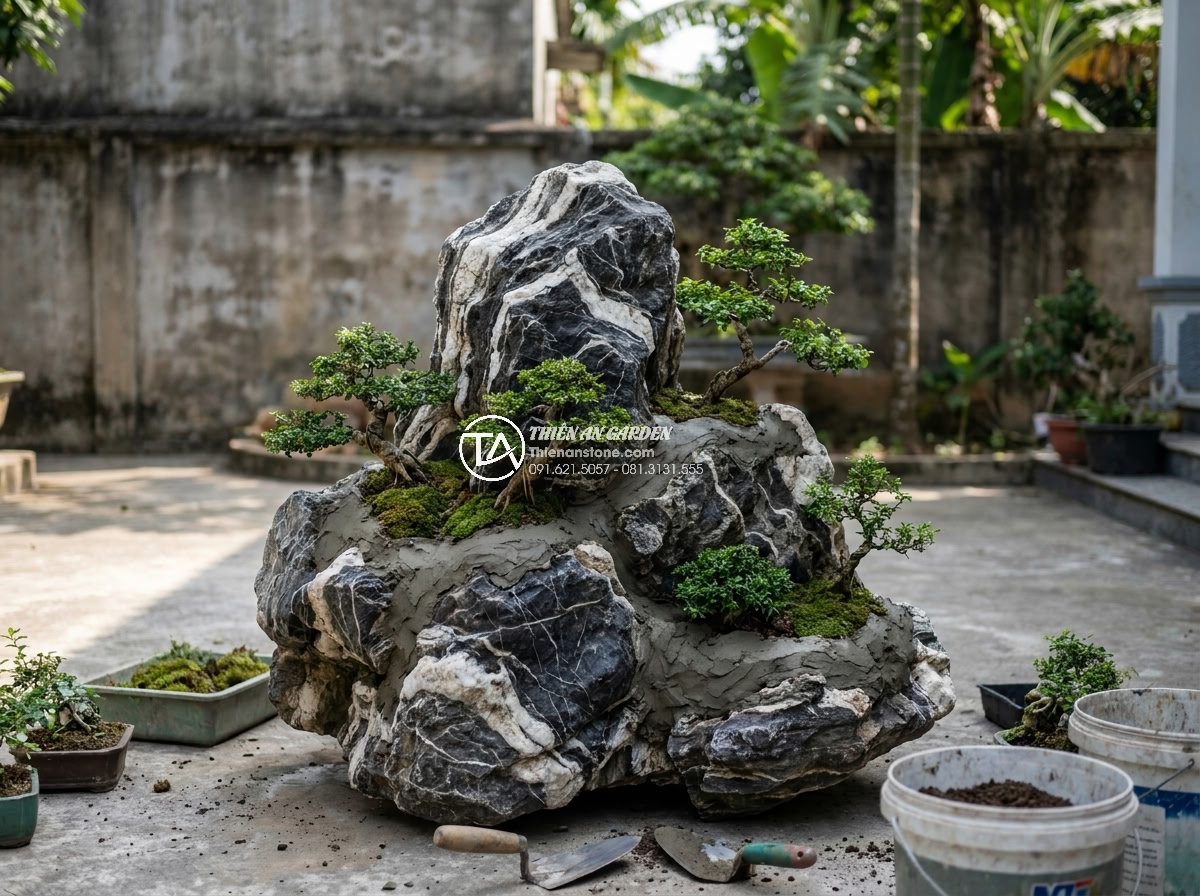 Kỹ Thuật Kết Hợp Đá Tuyết Sơn Và Cây Cảnh Trong Non Bộ - Hình 10 Kỹ Thuật Kết Hợp Đá Tuyết Sơn Và Cây Cảnh Trong Non Bộ - Final assembly stage showing trees being planted into carved crevices of Tuyet S