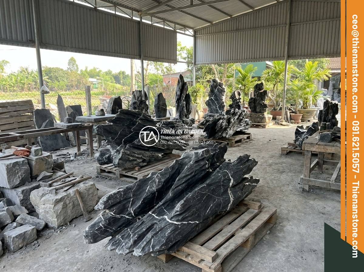 Quy Trình Chế Tác Đá Non Bộ Nguyên Khối Tại Xưởng Điêu Khắc - Professional team at Da Canh Thien An workshop proudly displaying finished monol