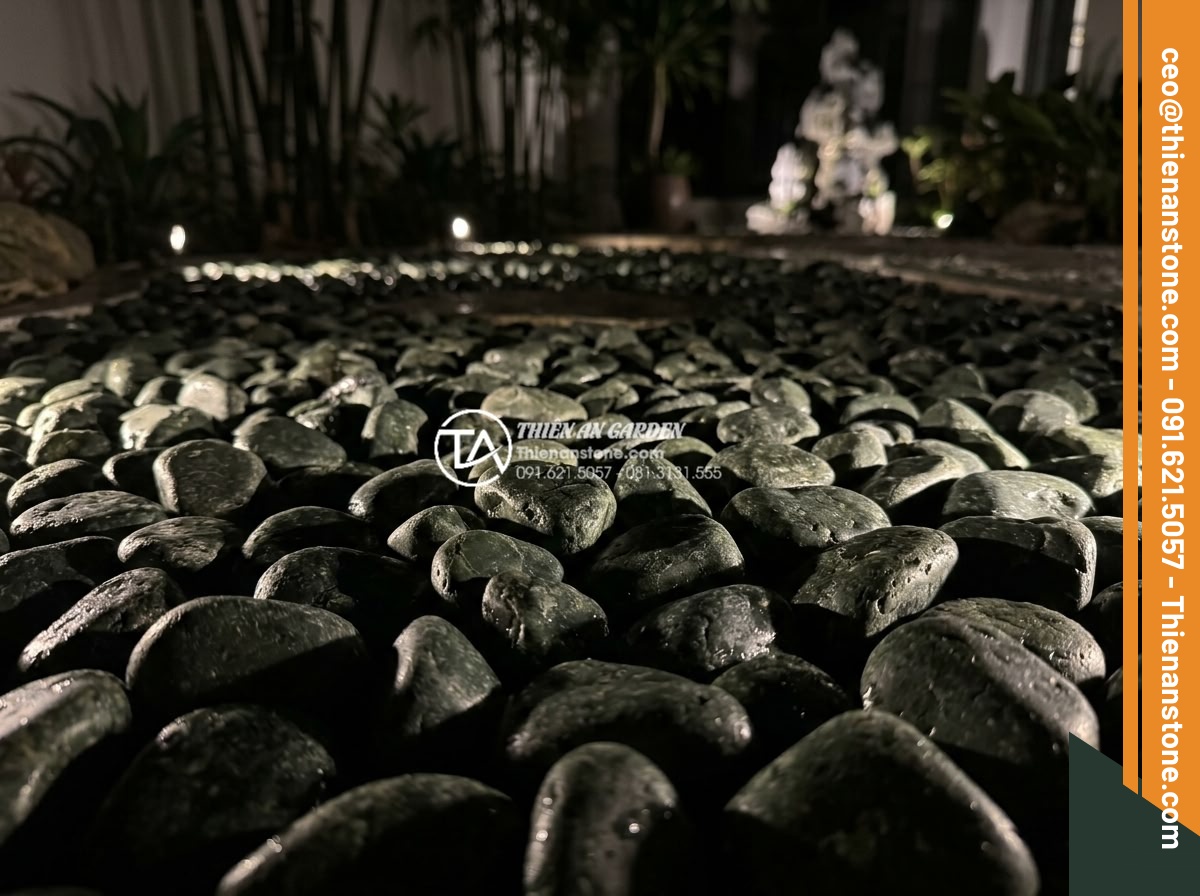 Sỏi Cuội Lớn: Cách Tạo Điểm Nhấn Cho Sân Vườn Khô Zen Garden - Nighttime view of illuminated large pebbles with subtle LED lighting enhancing t