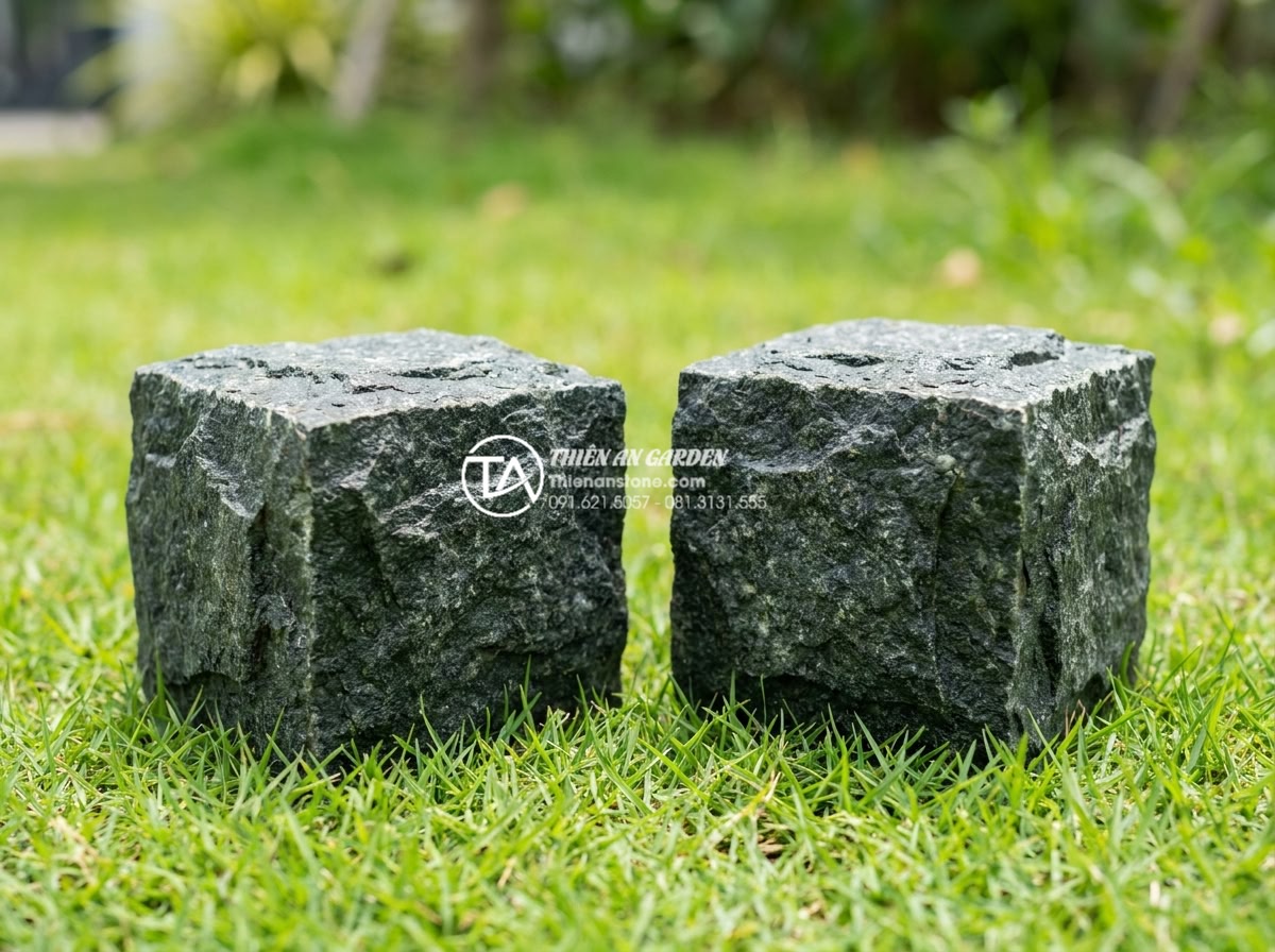 Đá cubic tự nhiên: Tại sao là lựa chọn số 1 cho công trình bền vững? - Hình 4 Đá cubic tự nhiên: Tại sao là lựa chọn số 1 cho công trình bền vững? - Side-by-side comparison of cubic basalt and cubic granite stones placed on green