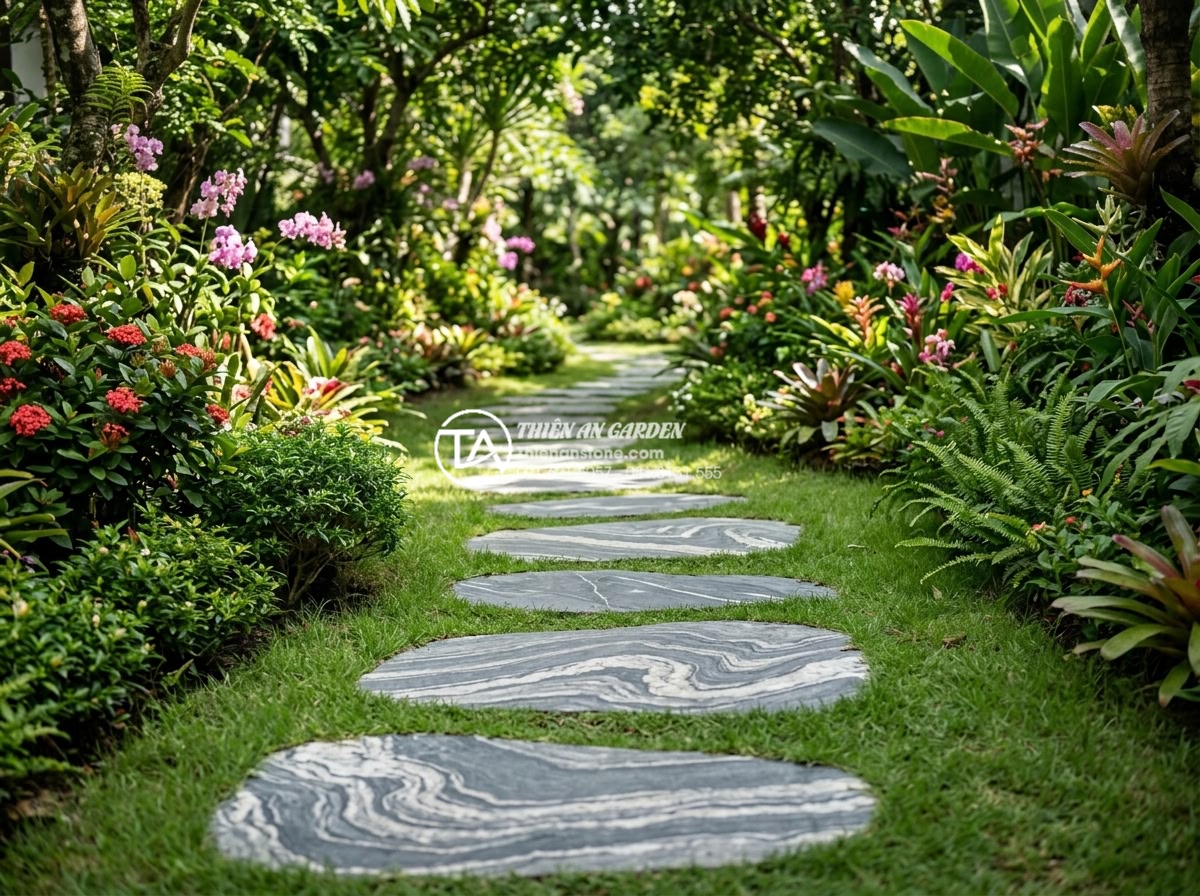 Đá dậm bước là gì? Vai trò và ý nghĩa của lối đi đá trong sân vườn - Natural granite stepping stones arranged in a curved path through a lush tropica