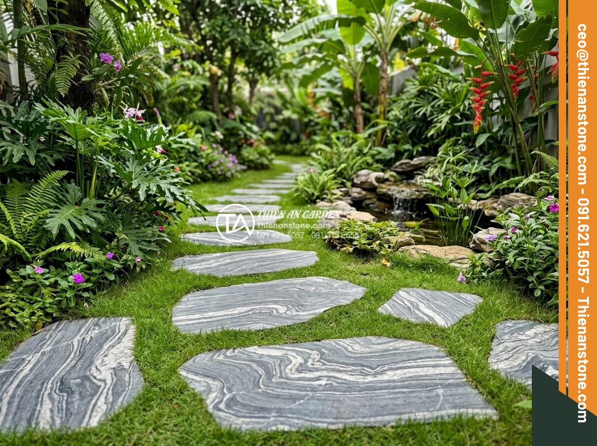 Dự toán chi phí vật tư đá dặm bước sân vườn cho diện tích 100m2 - Hình 1 Dự toán chi phí vật tư đá dặm bước sân vườn cho diện tích 100m2 - Natural stone stepping stones pathway arranged in a lush tropical garden with gr