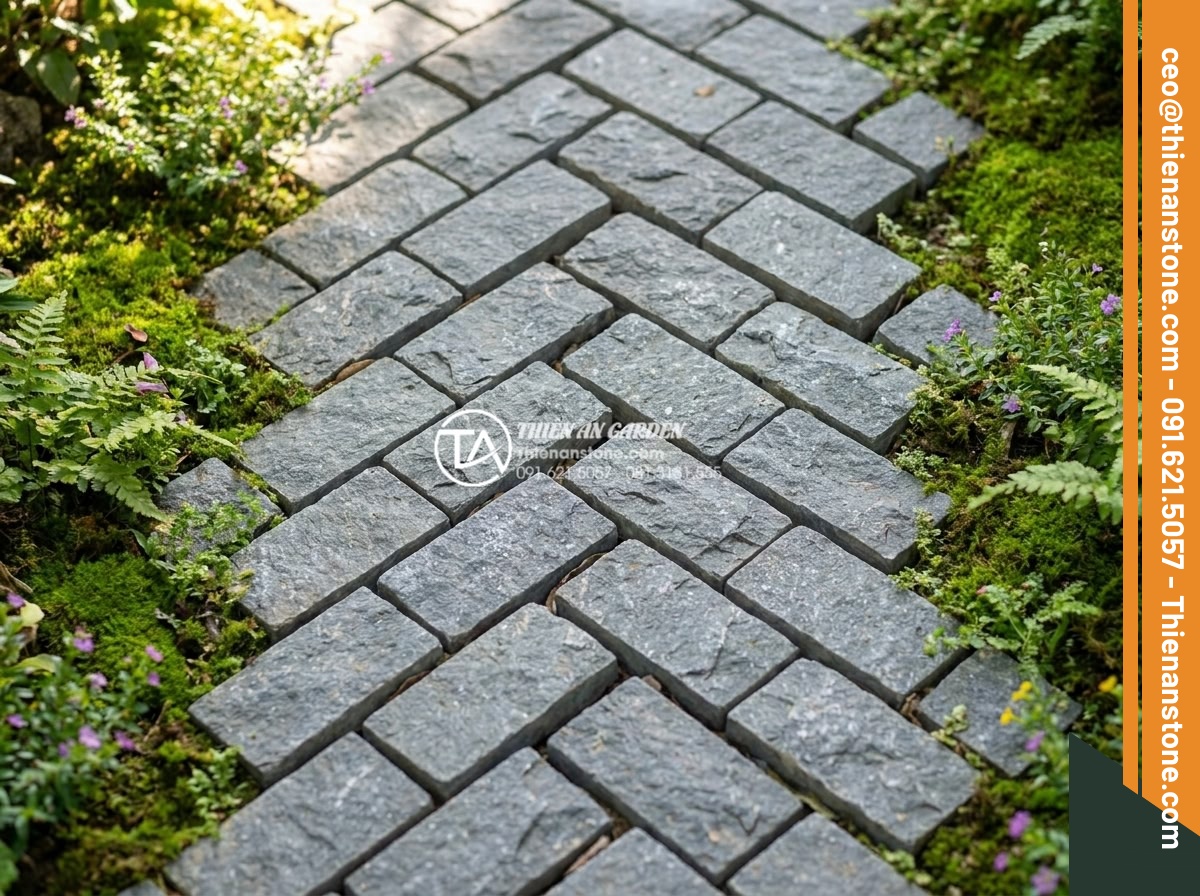 Kỹ thuật lát đá cubic kiểu xương cá (Herringbone) tạo hiệu ứng chiều sâu - Hình 2 Kỹ thuật lát đá cubic kiểu xương cá (Herringbone) tạo hiệu ứng chiều sâu - Detailed close-up view of natural granite cubic stones laid in perfect herringbo