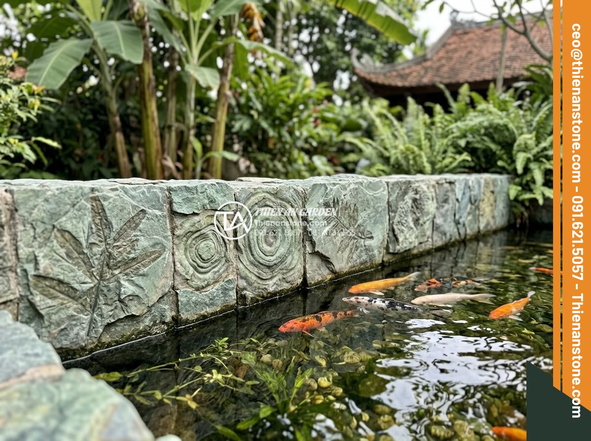 So sánh đá cổ thạch xanh và đá cổ thạch vàng: Nên chọn màu nào? - Green fossil stones used as Koi pond borders with fish swimming nearby