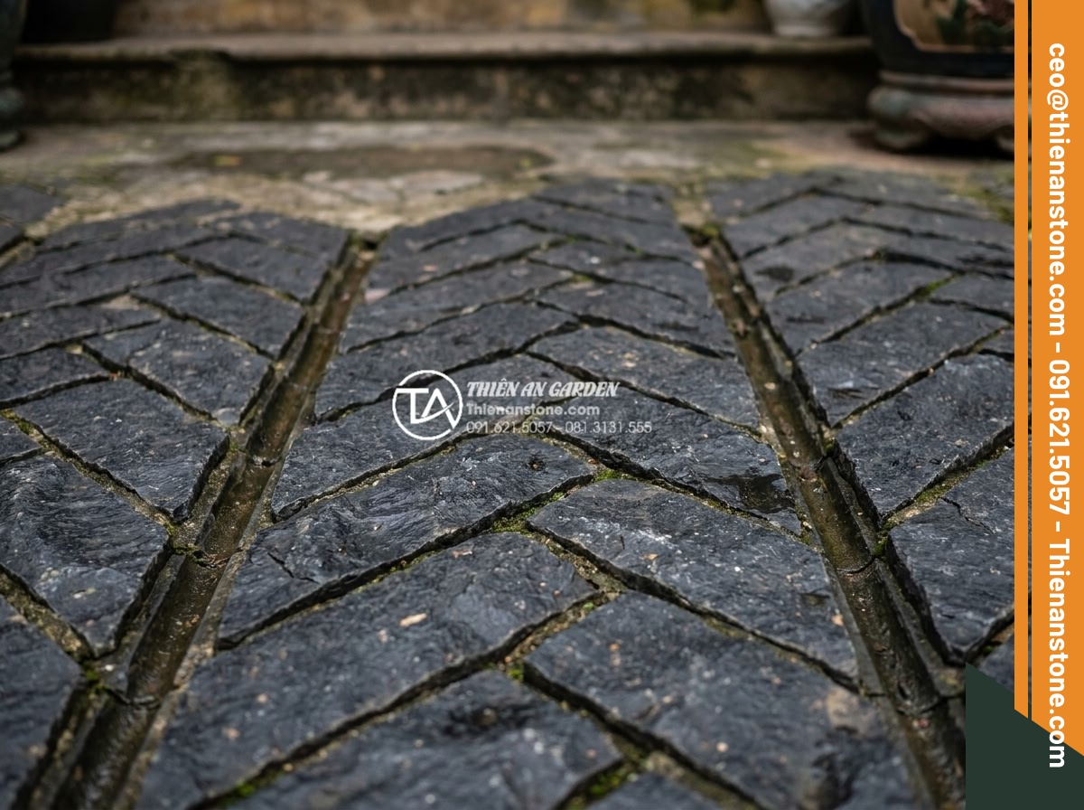 Top 15 mẫu lát đá cubic sân vườn đẹp mắt dẫn đầu xu hướng 2026 - Close-up detail of black cubic stone herringbone paving pattern with subtle wate