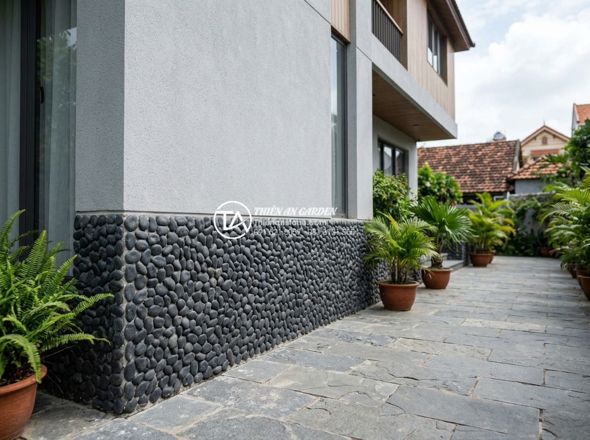 15+ Mẫu đá rối ốp chân tường giúp bảo vệ công trình tuyệt đối - Small black Lai Chau pebble stones neatly installed as wall base cladding on mod