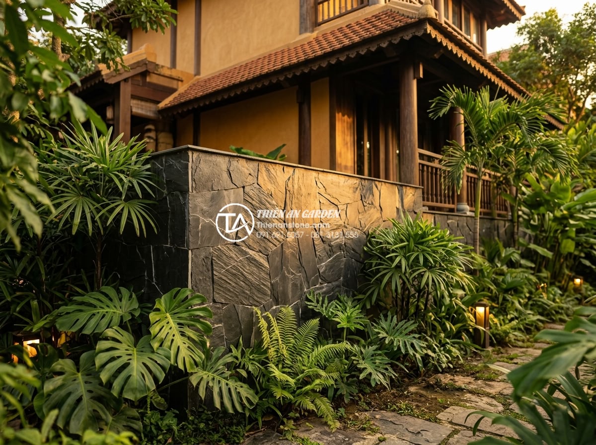 15+ Mẫu đá rối ốp chân tường giúp bảo vệ công trình tuyệt đối - Golden yellow natural pebble stones cladding wall base of a tropical garden vill