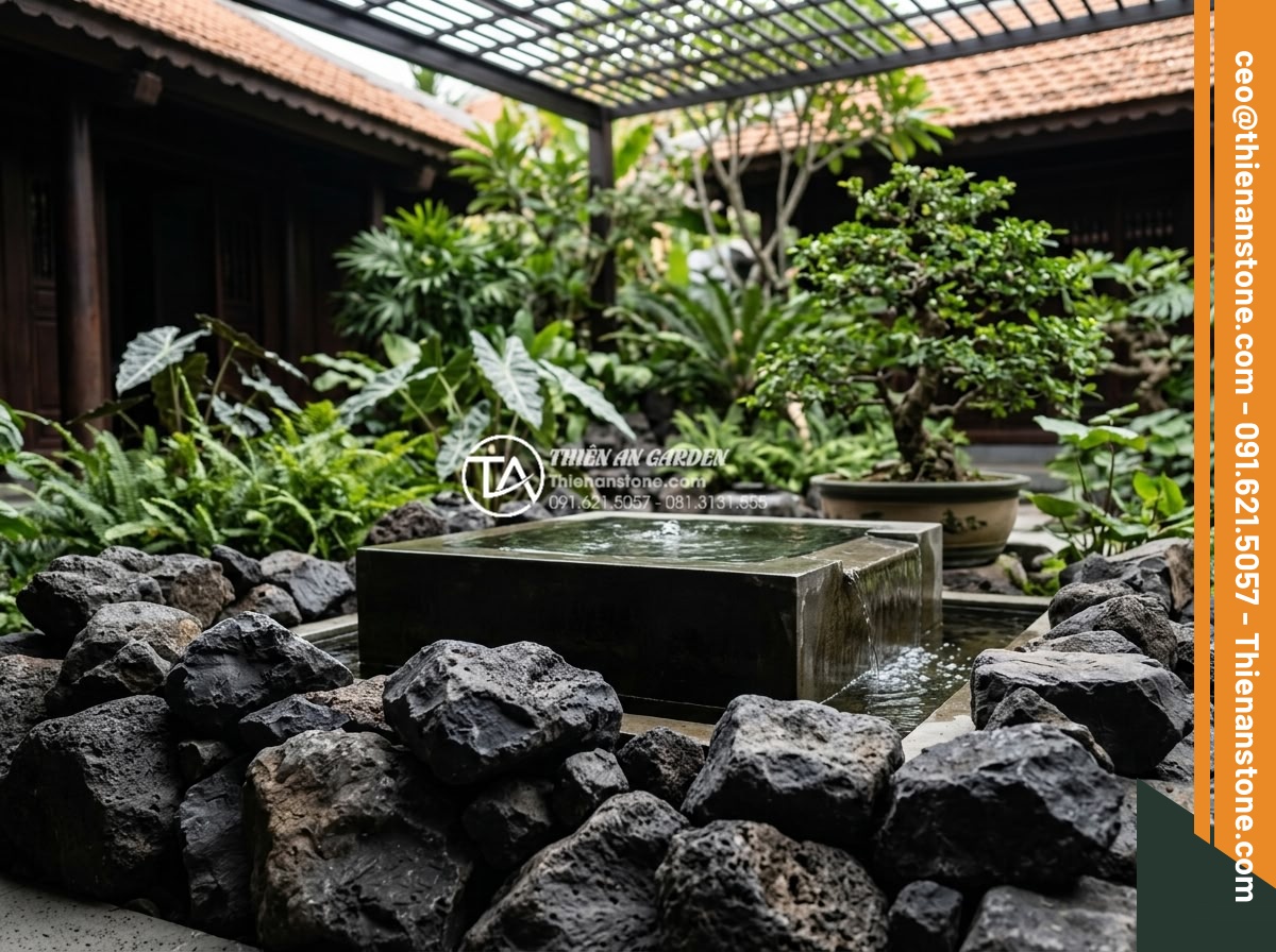 Cách chọn màu đá rối hợp mệnh gia chủ trong kiến trúc - Dramatic black rubble stones placed around a modern water feature in Feng Shui i