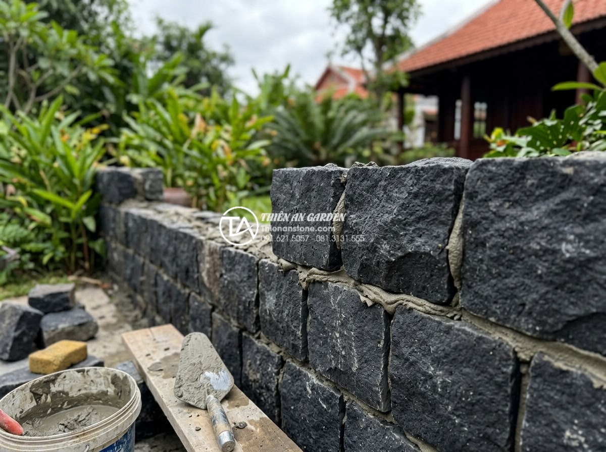 Đá rối đa sắc: Lựa chọn hàng đầu cho các resort và villa cao cấp - Professional construction workers installing multi-colored river stones on a vil