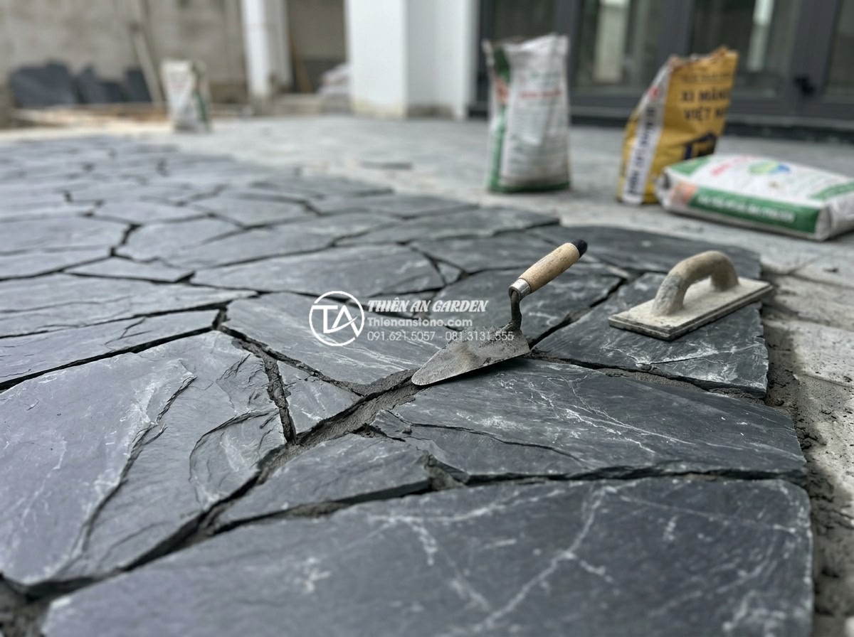 Kỹ thuật chà ron đá rối: Bí quyết để có mạch đá đều và đẹp - Technician using specialized grouting tools on natural chaotic stones, capturing