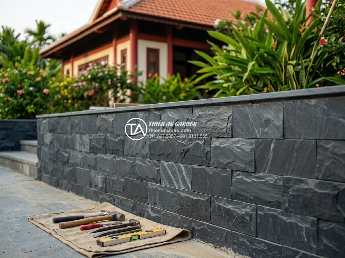 Ưu điểm của đá rối vàng ốp tường trong phong thủy nhà ở - Finished beautifully installed golden stone wall with tools and team in backgrou