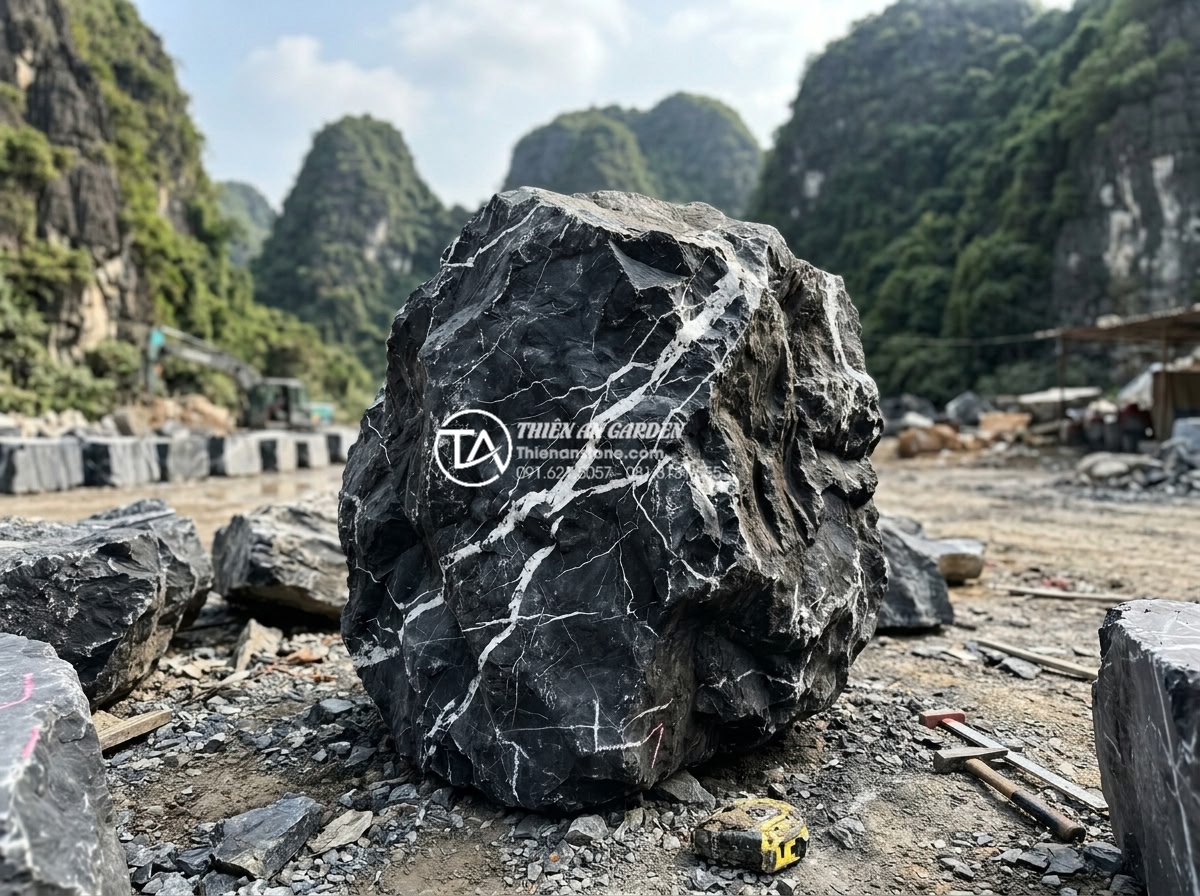 Thi công non bộ đá lũa đen: Quy trình và ý nghĩa phong thủy 2026 - Process photo of expert selecting large black lava stones at Ninh Binh quarry fo