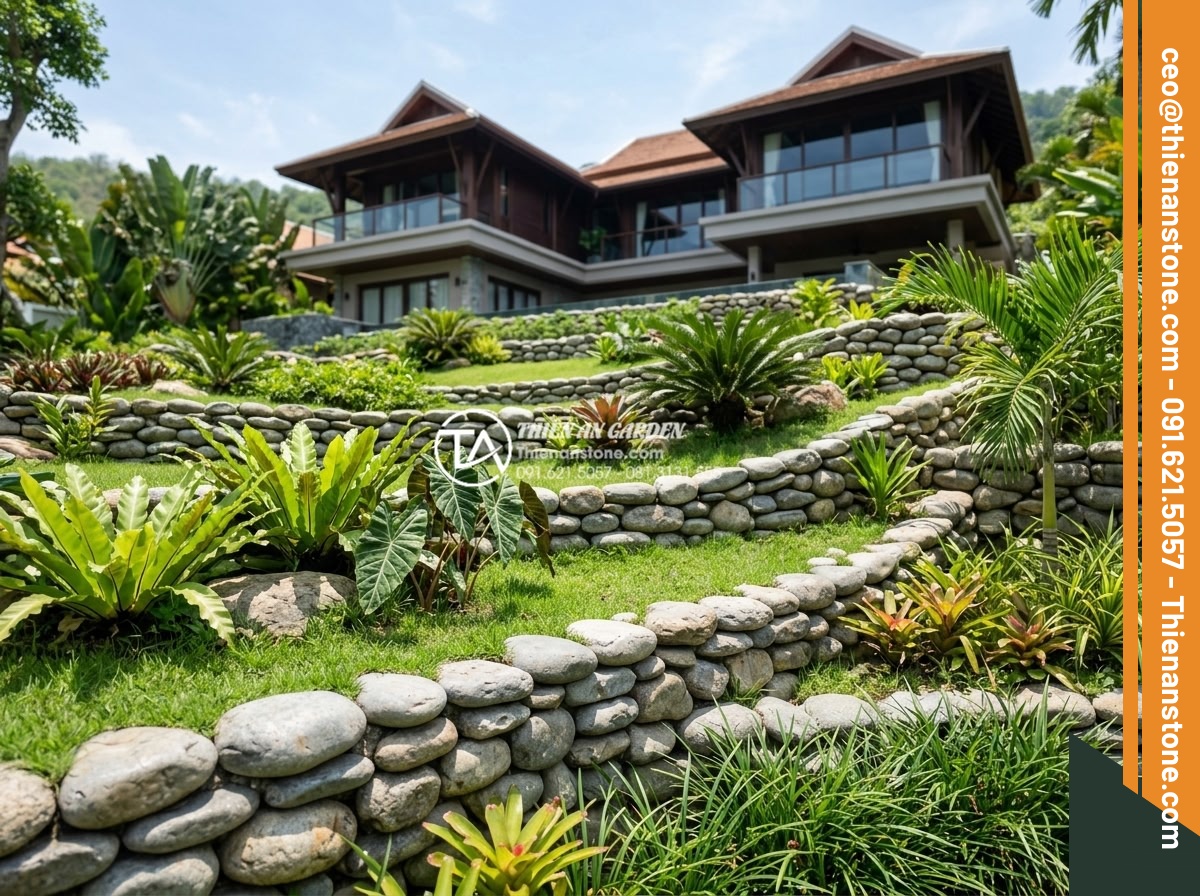 Ứng dụng đá cuội suối trong việc ngăn chặn xói mòn đất sân vườn biệt thự - Wide angle view of a luxury villa garden slope protected by layered river pebble
