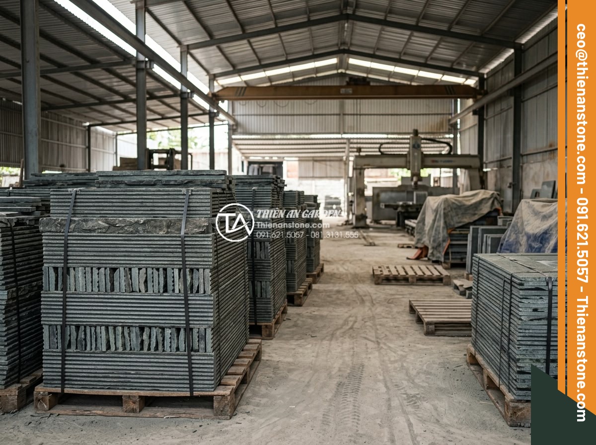 Case Study: Cải tạo mảng tường cũ bằng đá răng lược xám tại biệt thự Quận 2 - Hình 14 Case Study: Cải tạo mảng tường cũ bằng đá răng lược xám tại biệt thự Quận 2 - Factory interior view showing stacks of finished gray tooth comb stone slabs rea