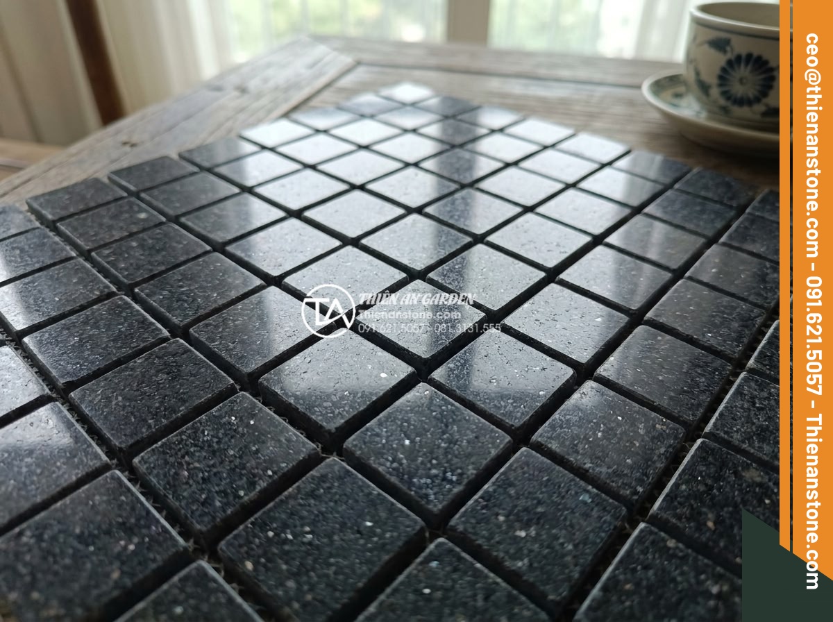 Đá ghép đen và đá ghép vân gỗ: Sự kết hợp hoàn hảo cho không gian nội thất - High resolution close-up of polished black mosaic stone texture showing natural 