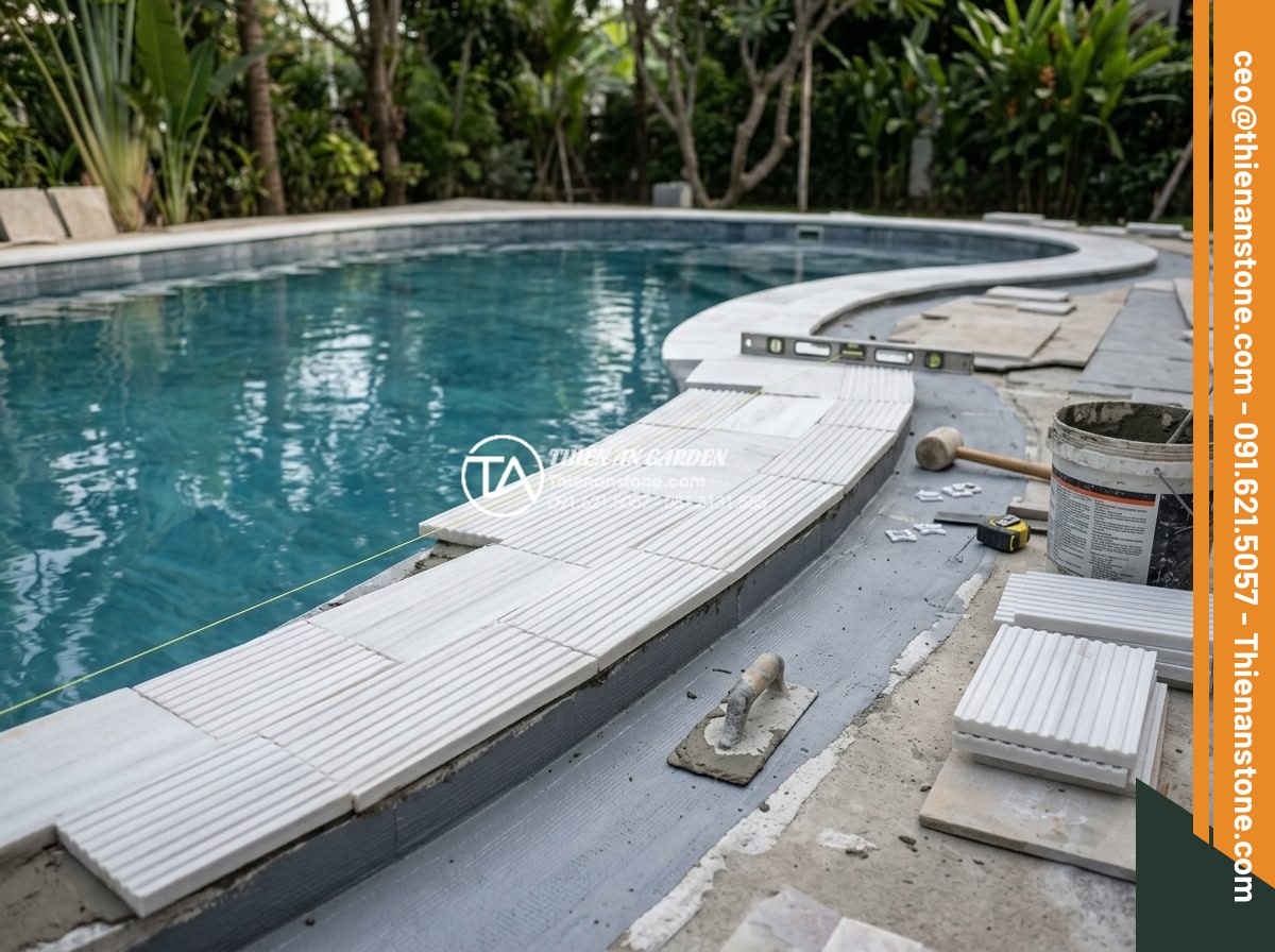 Đá răng lược có dùng được cho khu vực hồ bơi không? Những lưu ý quan trọng - Hình 13 Đá răng lược có dùng được cho khu vực hồ bơi không? Những lưu ý quan trọng - Professional installation team applying da rang luoc stone around pool edge with