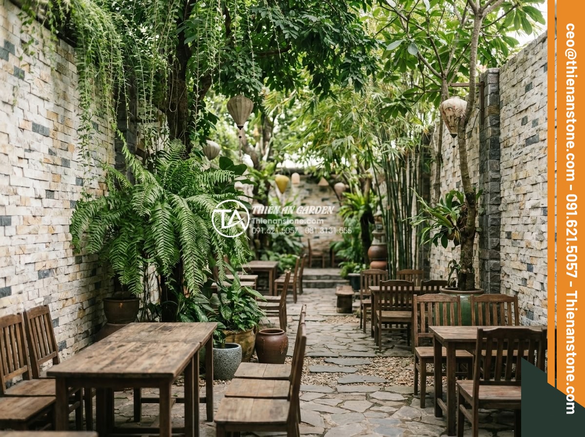 Khám phá vẻ đẹp mộc mạc của đá ong ghép 10x50 trong thiết kế Cafe sân vườn - Wide angle shot of a cozy outdoor cafe garden featuring 10x50 honeycomb stone cl