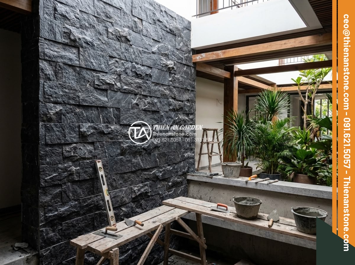 Kinh nghiệm chọn đá ghép đen ốp giếng trời tạo chiều sâu cho không gian - Expert masons applying black natural stacked stones to atrium structure with pre