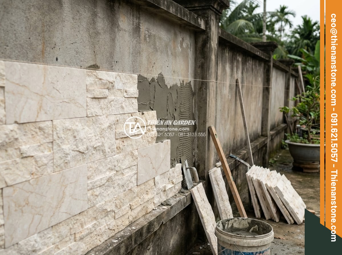 Quy trình thi công đá ghép tổ ong 10x50 cho tường rào và tiểu cảnh - Hình 11 Quy trình thi công đá ghép tổ ong 10x50 cho tường rào và tiểu cảnh - Skilled mason carefully installing 10x50 honeycomb stone pieces onto a perimeter