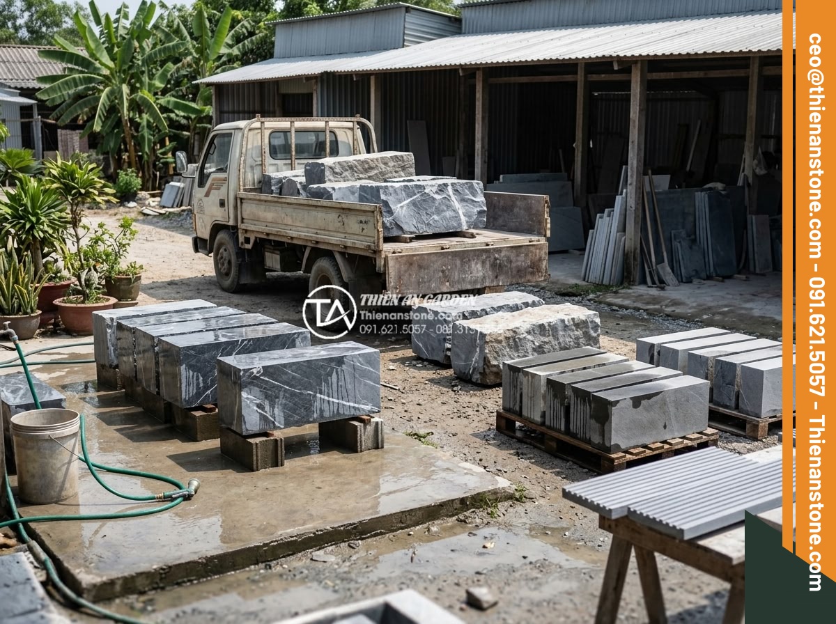 Tìm hiểu quy trình sản xuất đá chẻ răng lược thủ công tại làng nghề - Workers unloading large natural stone blocks from a truck at a traditional Vietn