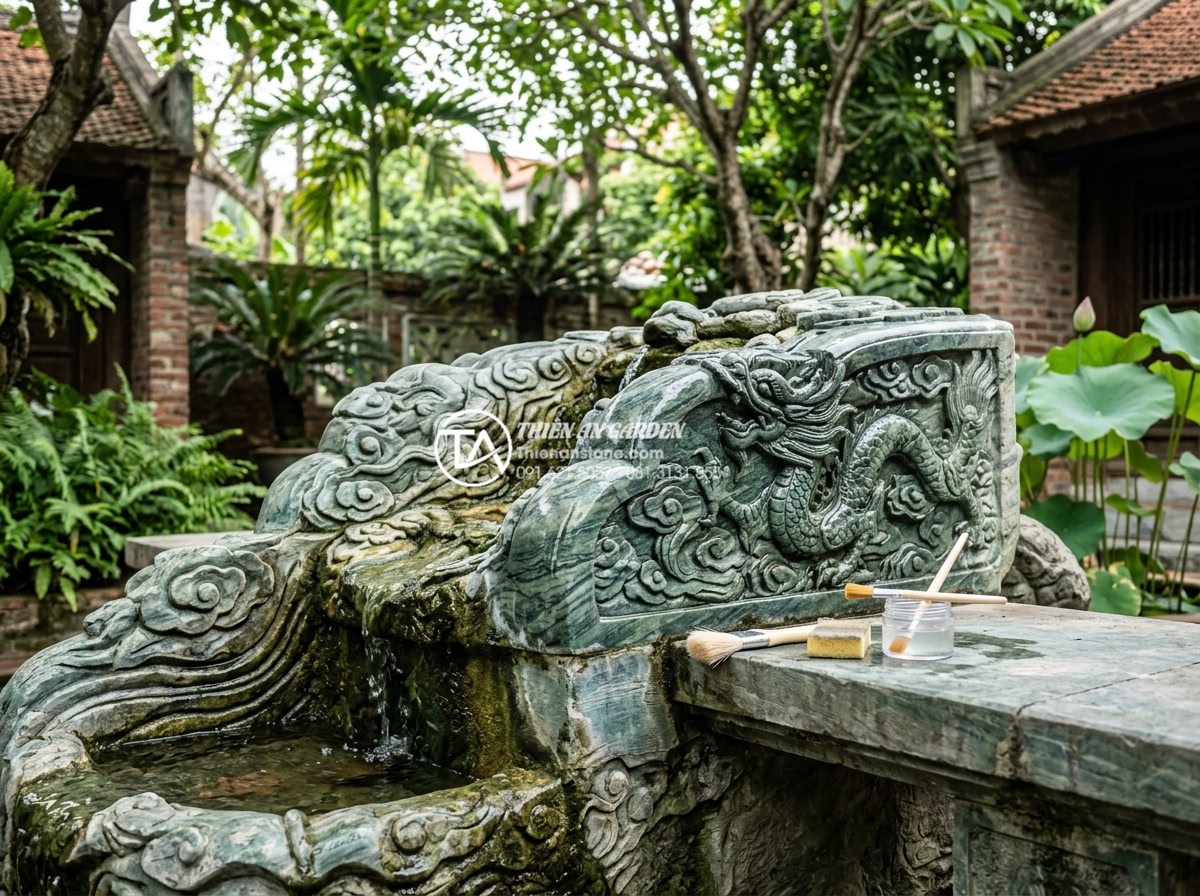Checklist 10 bước bảo trì tiểu cảnh nước sân vườn luôn hoạt động trơn tru - Expert gently cleaning intricate natural stone carvings on a water feature using