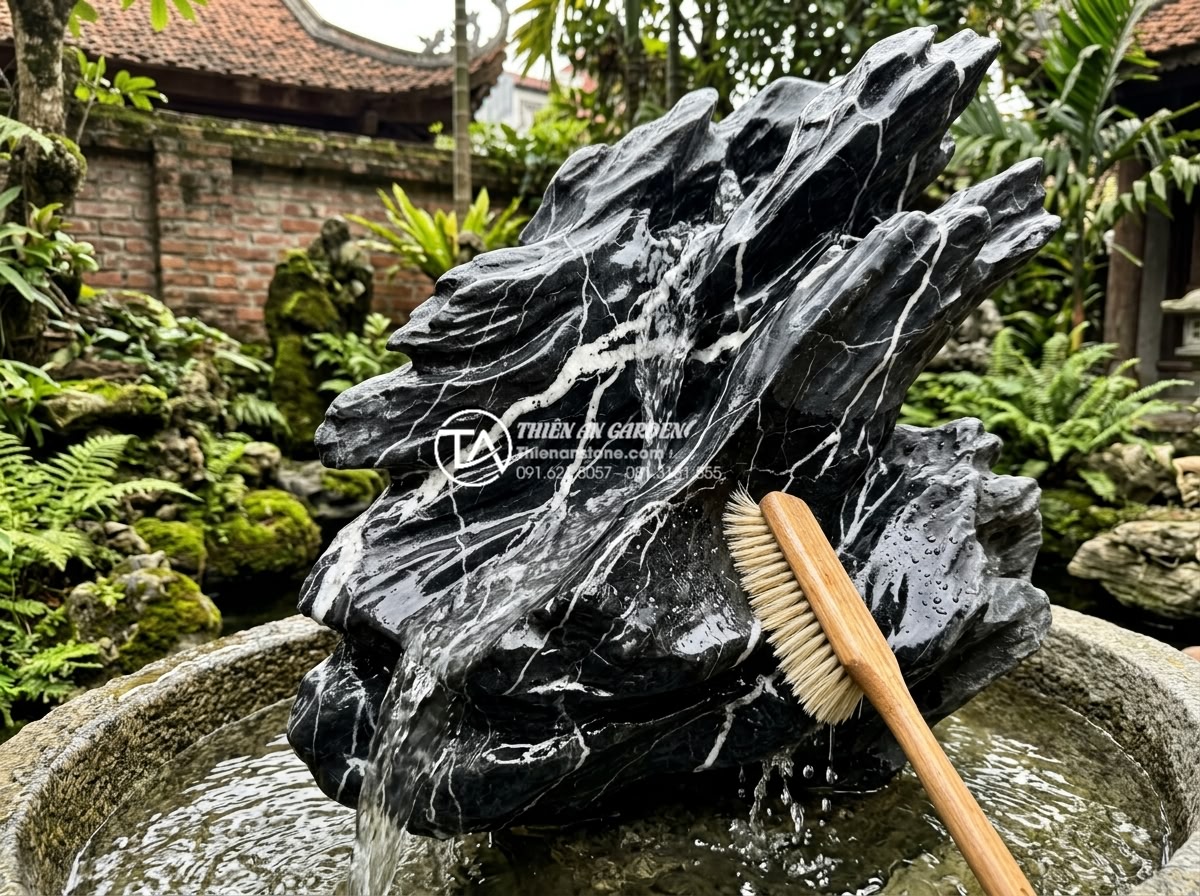 Review 5 loại đá tự nhiên tốt nhất để làm tiểu cảnh nước chảy bền đẹp - Maintenance process showing cleaning of natural stone water feature with soft br