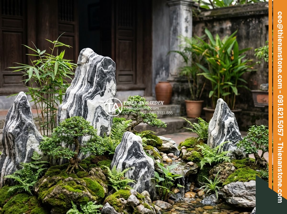 Báo giá đá tuyết sơn mới nhất 2026: Đơn giá theo tấn và theo khối - Professional landscape designer arranging snow mountain stone pieces in a mock g