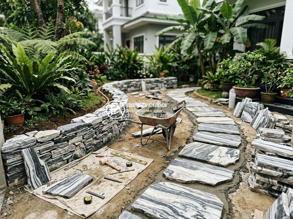5 Lỗi phong thủy nghiêm trọng khi đặt tiểu cảnh sân vườn trước nhà - Professional stonemasons installing high-quality natural stone features in a fro