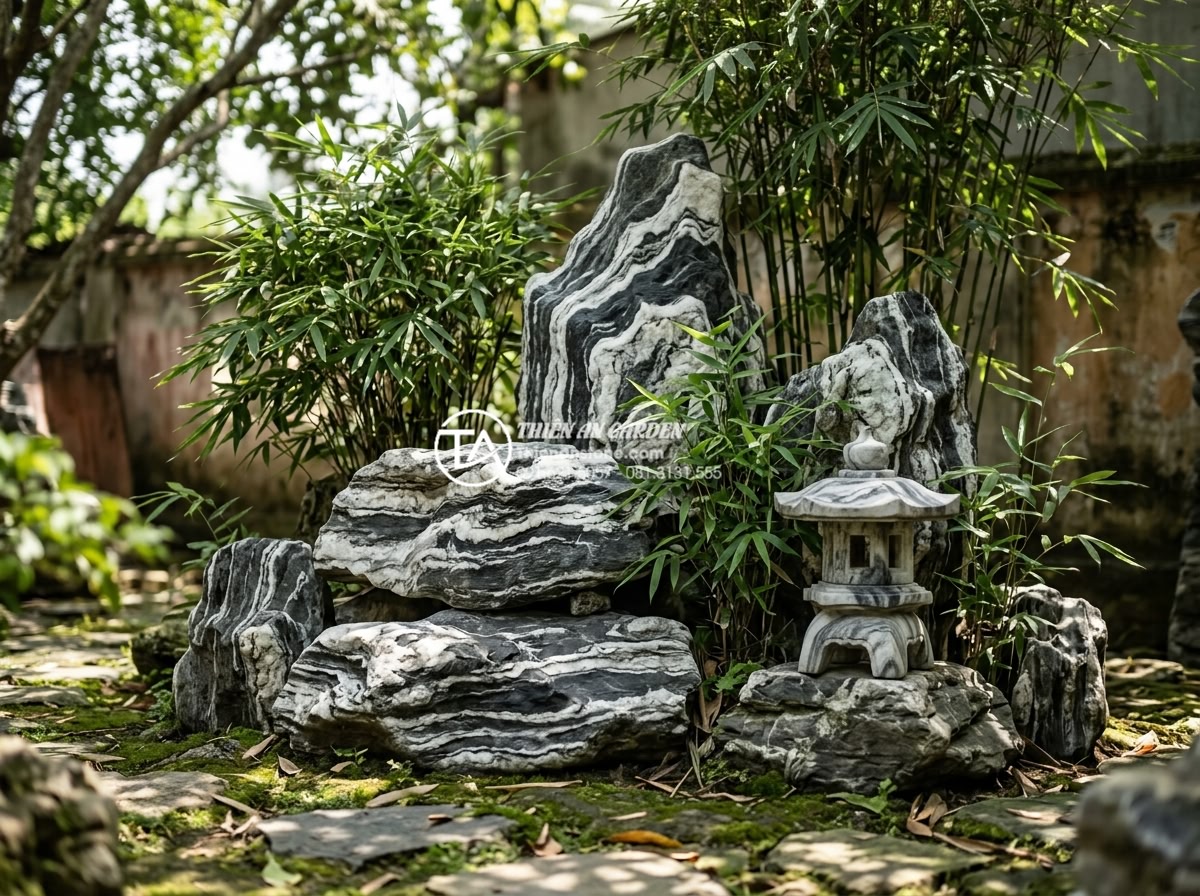 Top 10 loại đá tự nhiên trang trí tiểu cảnh góc sân bền đẹp vĩnh cửu - Rugged basalt stones stacked to form natural rock formation in garden corner wit