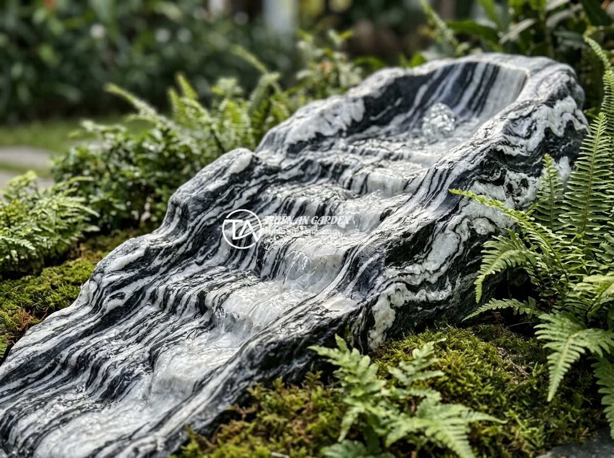 Kinh nghiệm thuê thợ thi công tiểu cảnh đá: Cách tránh tiền mất tật mang - Detailed close-up of hand-carved natural stone water feature in a luxury resort 