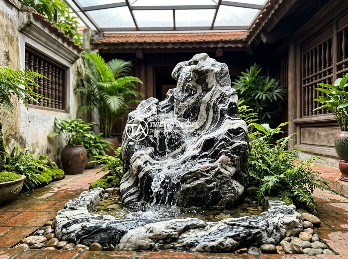 Sự kết hợp hoàn hảo giữa đá mỹ nghệ và nước trong tiểu cảnh giếng trời - Flowing water cascading over beautifully carved natural art stone in a bright sk